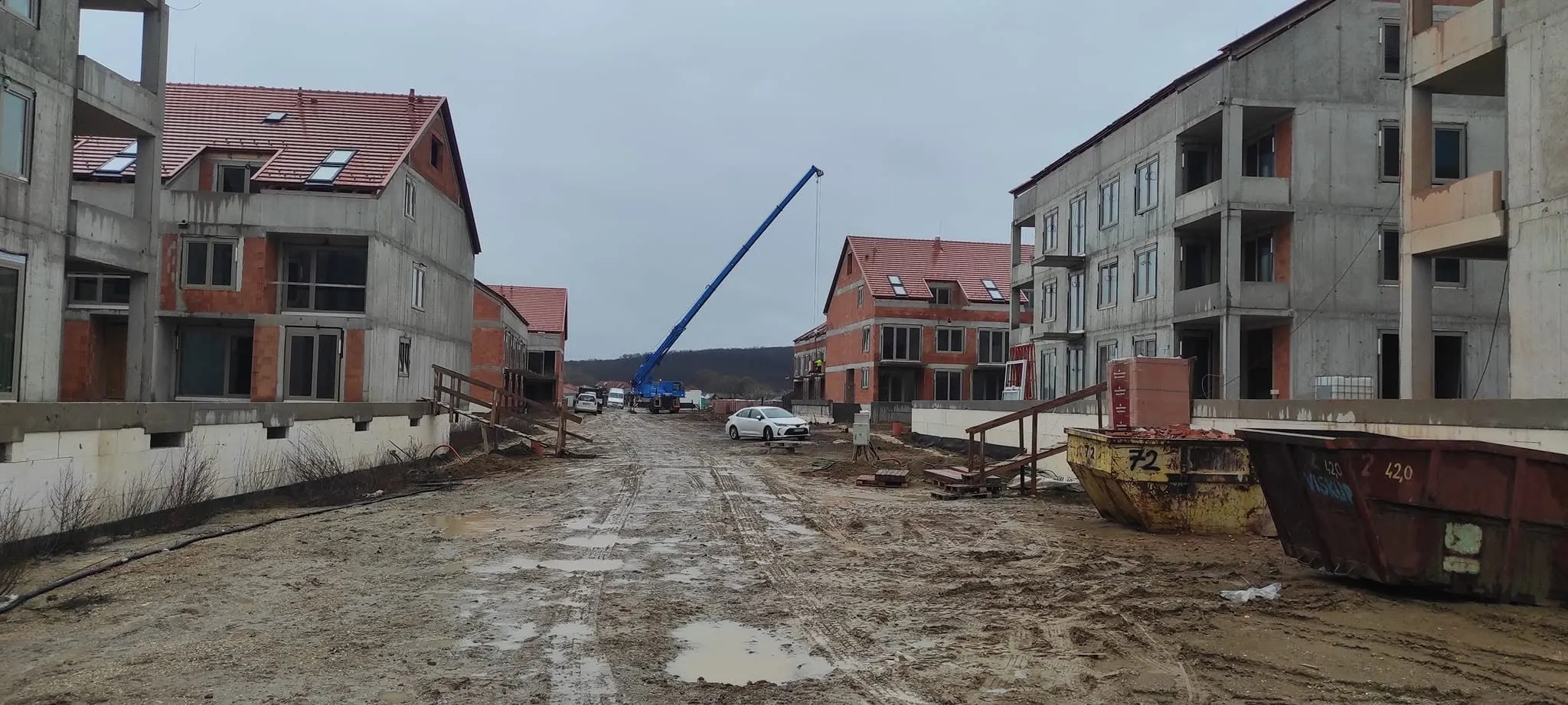 Autožeriav s vysunutým výložníkom na stavbe bytových domov